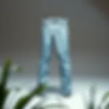 A pair of tapered light wash jeans displayed on a minimalist background.