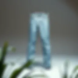 A pair of tapered light wash jeans displayed on a minimalist background.