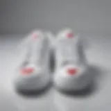 Elegant display of white sneakers featuring heart motifs on a reflective surface